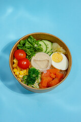 Bento Bowl with Eggs and Greens on Blue Background