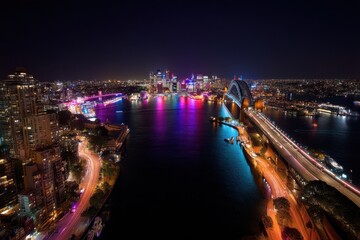 Obraz premium Pylon Outlook: A Vibrant Nightscape of Sydney's Colourful City Skyline and Illuminated Bridge Over the Water