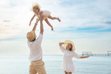 Family, children and fun on the beach during summer vacation. Happy parents, daughter, tropical vacation, outdoors and smiles.