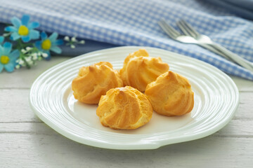 Cream puffs filled with vanilla custard cream on white plate