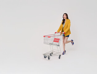 Full length happy excited Asian business woman pushing empty shopping cart or shopping trolley...