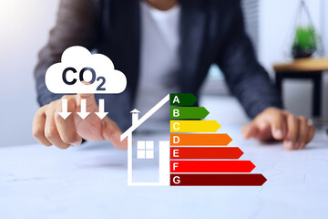 House energy efficiency rating labeling with businessman pointing on co2 reduce sign to improve...