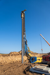 The yellow vibrating piling machine removes Larssen sheet piling from the ground