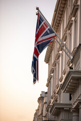 A picturesque British flag displayed prominently on a historic building at sunset