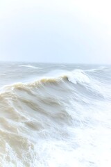 Fototapeta premium A powerful ocean wave crashes under a stormy, pale sky