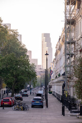 A vibrant urban street scene showcasing modern architecture alongside lush trees in the area Saint Georges Drive - London