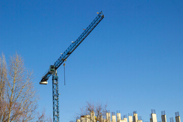 The beginning of construction: a construction crane and reinforced concrete slabs against the background of  sky.