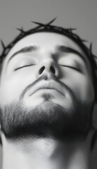 Close-up grayscale portrait of a man with closed eyes, wearing a crown of thorns