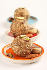 Healthy snacks, fitness lifestyle and high fiber diet concept with dates and dryfruits energy Laddus or Ladoo surrounded by dried fruits, Cashew Nuts, pistachios , almonds