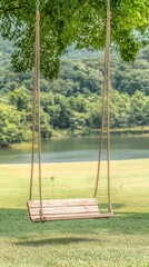 Serene lakeside scene with a rustic wooden swing hanging from a tree, overlooking tranquil waters and lush green hills