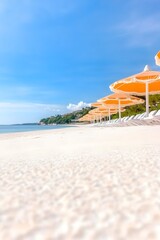 Obraz premium Serene beach scene with rows of orange umbrellas and white lounge chairs under a bright blue sky
