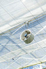 the fans in the green house hanging from roof,  high tech