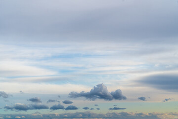 Stormy sky with dark, snowy clouds on a spring day. Clouds are floating across the sky. Dramatic clouds. Dark blue clouds swiftly floating across blue sky. Sky texture, abstract nature background.