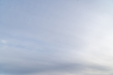 Stormy sky with dark, snowy clouds on a spring day. Clouds are floating across the sky. Dramatic clouds. Dark blue clouds swiftly floating across blue sky. Sky texture, abstract nature background.