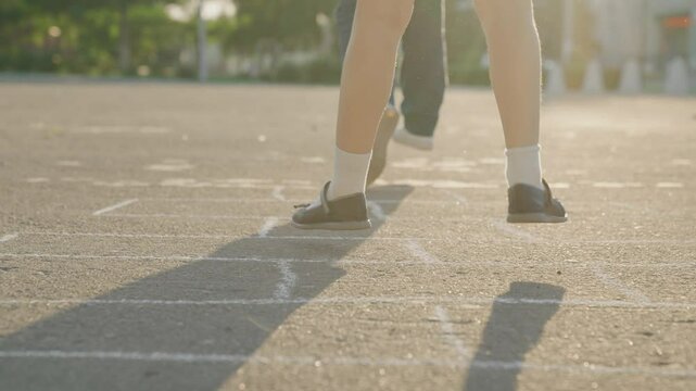 Kid child baby boy girl happy family, child dream, Children's joyful energy, pavement chalk game, old-school fun, sunlight glowing moment, dynamic hopscotch frame, heel lift jump, skipping stone play