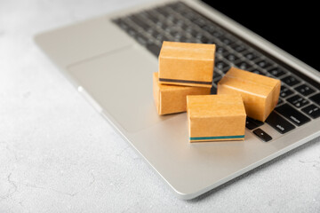 Online shopping concept.Cardboard box and shopping bags in a trolley on a bright colored background. Shopping basket. Online shopping using a laptop, tablet, phone and credit card. Home delivery.