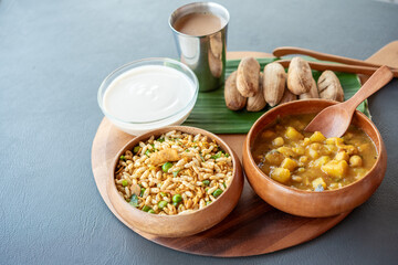 A wooden tray with three bowls of food on it, including a bowl of rice