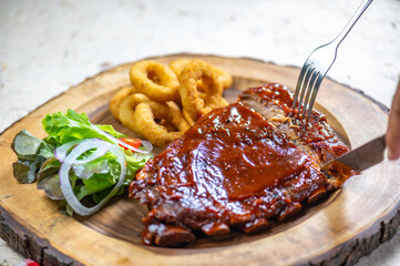 Plate of ribs and a salad with a fork