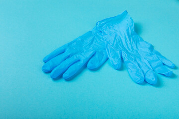 Medical nitrile gloves,blue cap, disposable medical mask on textured background. Medic protective clothing. Surgical latex gloves. Rubber gloves manufacturing.Medicine concept. Top view. Copy text