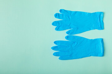 Medical nitrile gloves,blue cap, disposable medical mask on textured background. Medic protective clothing. Surgical latex gloves. Rubber gloves manufacturing.Medicine concept. Top view. Copy text
