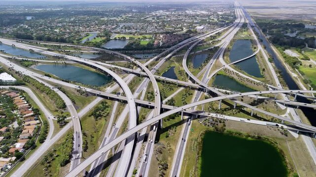 A raised highway interchange in Miami, bustling with the fast moving vehicles, showcasing U.S. transportation infrastructure under a cloudy sky. Close up view.