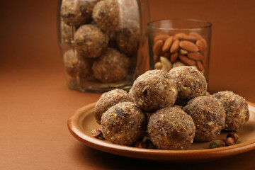 Healthy snacks, fitness lifestyle and high fiber diet concept with dates and dryfruits energy Laddus or Ladoo surrounded by dried fruits, Cashew Nuts, pistachios , almonds