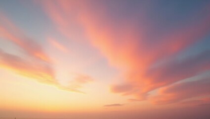 Fototapeta premium Panoramic sunset sky with pink, orange, and purple clouds blending into soft yellows and blues, capturing a serene, colorful moment just after sunset.