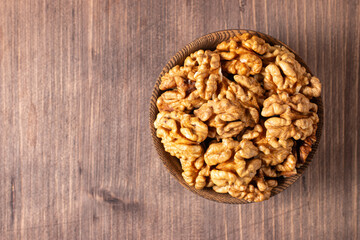 Walnuts nuts in a bowl on wooden background
