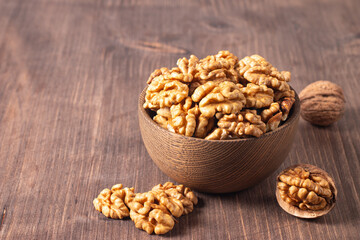 Walnuts nuts in a bowl on wooden background