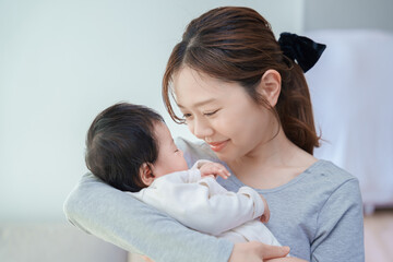 赤ちゃんを抱いて微笑む女性