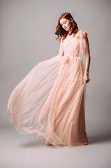 Elegant bridesmaid’s two-layer maxi gown. Gorgeous young sexy lady with curly hairstyle. Pink...