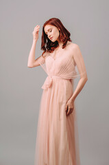 Elegant bridesmaid’s two-layer maxi gown. Gorgeous young sexy lady with curly hairstyle. Pink...