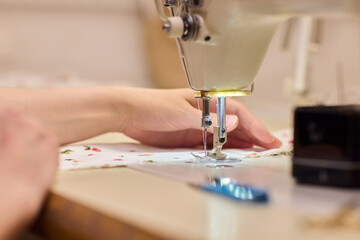 A Focused Seamstress Diligently Working with a Sewing Machine in Her Creative Workspace