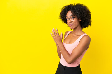 Young African American woman isolated on yellow background scheming something
