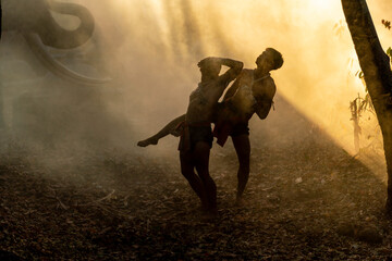 Traditional Muay Thai Fighters Sparring in Forest at Sunrise. Silhouettes of Martial Artists...