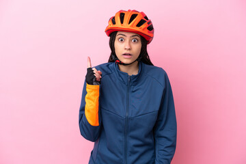 Teenager cyclist girl isolated on pink background intending to realizes the solution while lifting a finger up