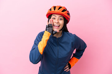 Teenager cyclist girl isolated on pink background shouting with mouth wide open