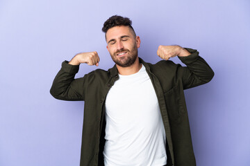 Caucasian man isolated on purple background doing strong gesture
