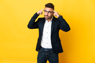 Businessman over isolated yellow background having doubts and thinking