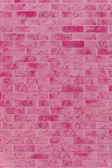 Wall of decorative pink bricks covered with imitation damage. The wall has an impressive appearance.