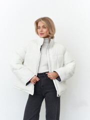 Stylish female model posing confidently in a chic winter outfit in a studio setting