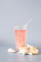 Enjoying Refreshing Summer Drink while wearing a Straw Hat surrounded by Seashells