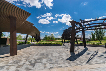 Beautiful public park during sunny day with modern architecture and lush landscaping in vibrant...