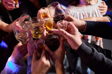 Elegant and Stunning Cocktail Glasses Clinking Together in a Softly Dimly Lit Bar Setting