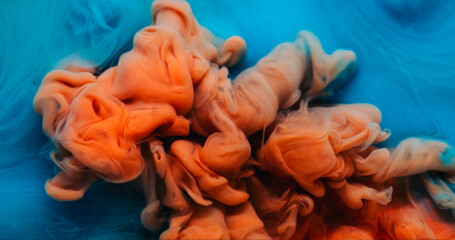 Ink drop explosion. Paint water. Defocused blue orange colorful ethereal splash chemical liquid floating on abstract art background.