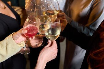 Elegant and Stunning Cocktail Glasses Clinking Together in a Softly Dimly Lit Bar Setting