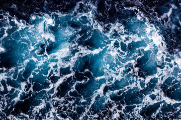 Ocean water surface texture. Aerial view of artistic water with foam. Can be used in covers, packaging, posters, textures, brochures, art and design projects. Awesome nature background image.