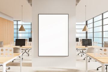 Framed blank poster mockup on white pillar wall in modern open-plan office interior with natural light and minimalist design elements. 3D Rendering