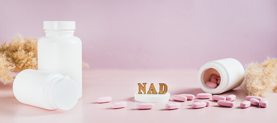 Nicotinamide adenine dinucleotide anti-aging pills and bottles on the table web banner