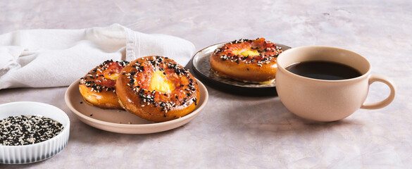 Baked bagel with tomato and quail egg on a plate on the table web banner